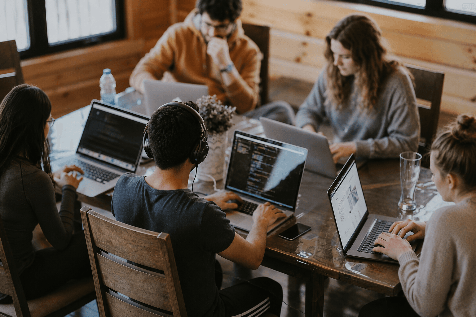 Team collaborating at a table with laptops